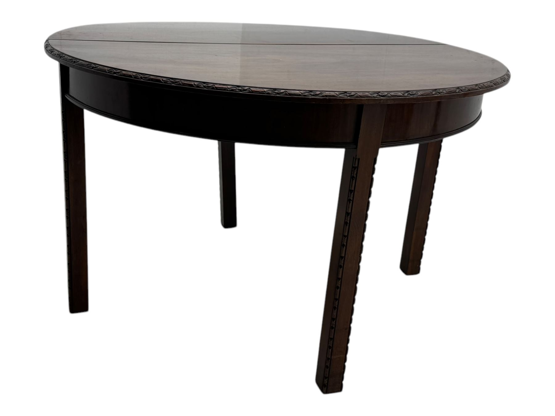 Early 20th century mahogany demi-lune table, the circular top with carved foliate border, raised on square section supports with relief carved edges