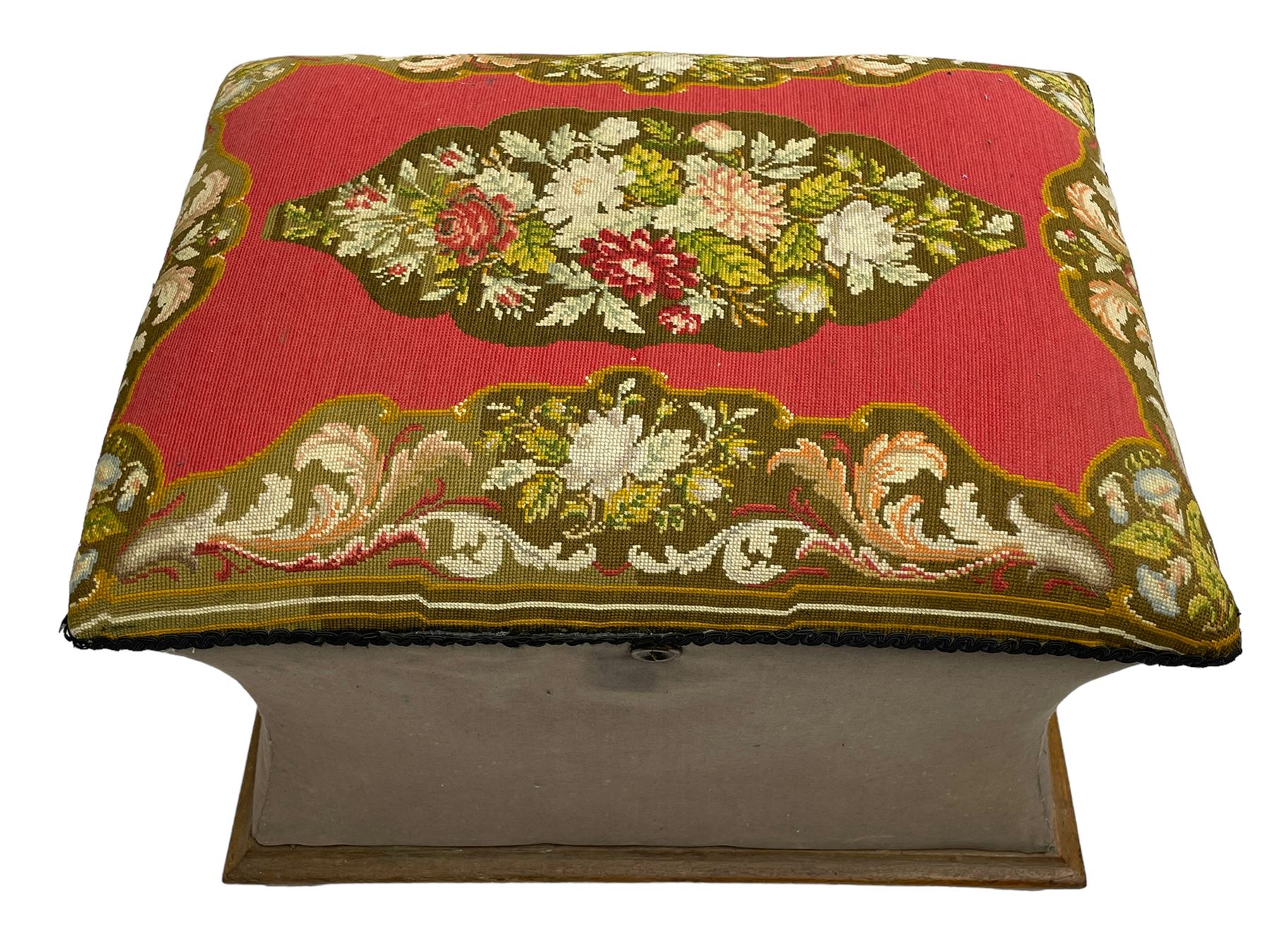 19th century upholstered ottoman, rectangular waisted form with hinged lid, upholstered in needle work cover decorated with floral panels and borders, the interior lined in blue fabric, lower moulded edge over compressed bun feet