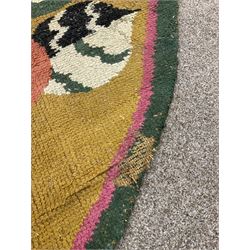 20th century wool oval rug, mustard ground and decorated with flower heads, with pink and green outer bands