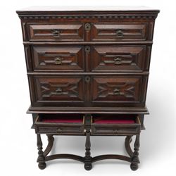 17th century oak chest on stand, moulded cornice over block work frieze, the upper section fitted with three long drawers each decorated with applied geometric mouldings and faceted panels, panelled sides with moulded frame, the stand fitted with two drawers, on five turned supports united by plan flat stretchers, terminating to turned feet
