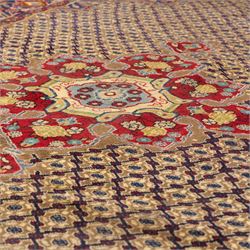 South West Persian Bidjar hand-knotted rug, olive and camel-toned field decorated with an all-over Herati lattice design with a central floral medallion within a wide floral border with shaped floral spandrels and multiple guard borders in tones of navy, ivory, crimson, and green, with cotton fringe ends  