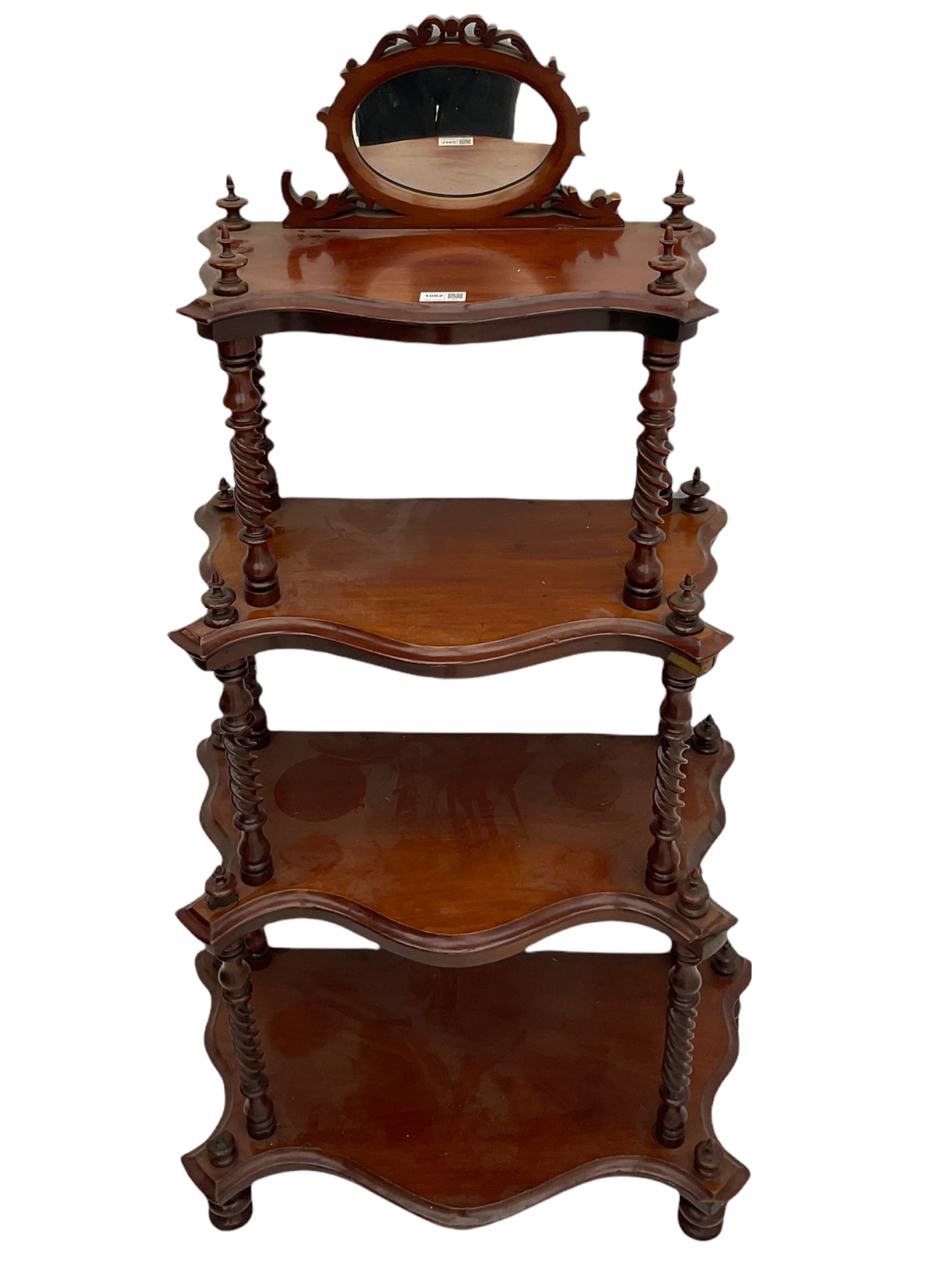 Victorian mahogany etagere, raised oval mirror in fretwork frame, four graduating shaped tiers, spiral turned supports