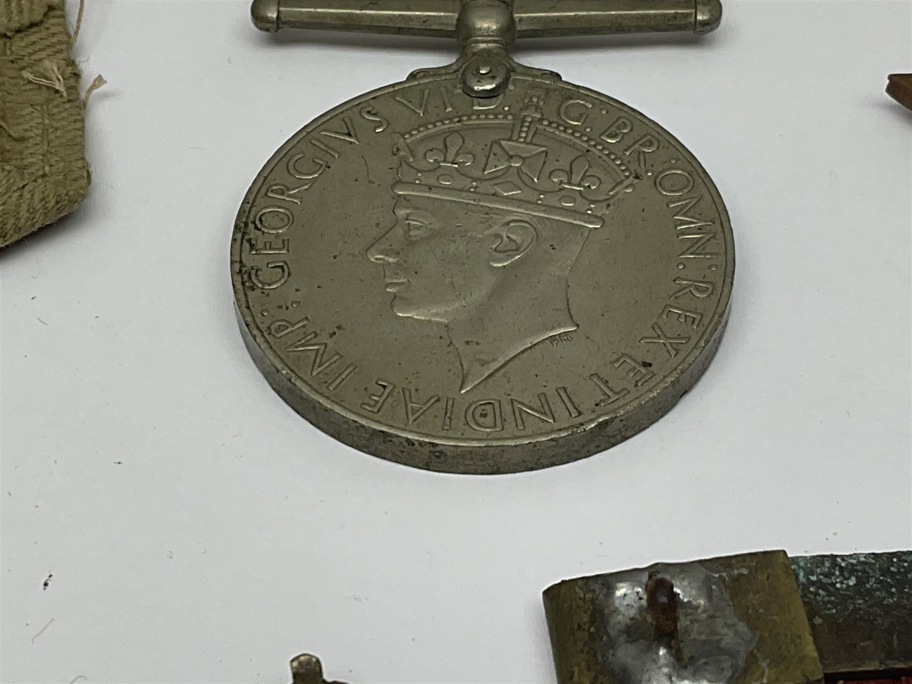 WWII group of three medals comprising 1939-45 War Medal and Italy and Africa Stars in issue box; dog tags for 282894 W. Wilkinson with framed photograph in uniform; and small quantity of cloth and metal badges including RAOC cap badge