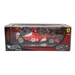 Signed Michael Schumacher Hot Wheels Ferrari 1:18 scale model, 2002 five-times World Champion edition depicting Schumacher sitting on the side of his car with arms raised, with his signature in black marker to wing of car, boxed