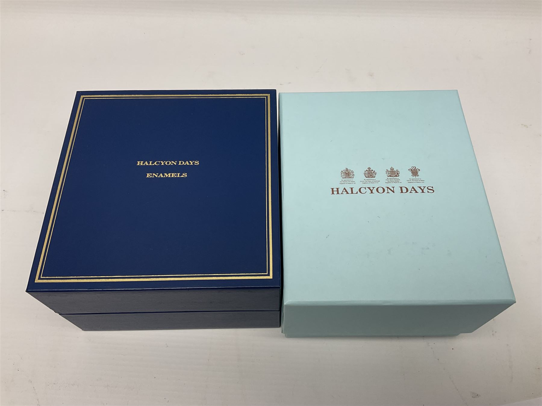 Two Halcyon Days enamel boxes, both of rectangular form, the first depicting Buckingham Palace, 'To Celebrate the Golden Jubilee of Her Majesty Queen Elizabeth', the second depicting the marriage of The Queen and Prince Philip, in celebration of their Diamond Wedding Anniversary, H4cm, W8.5cm, both boxed