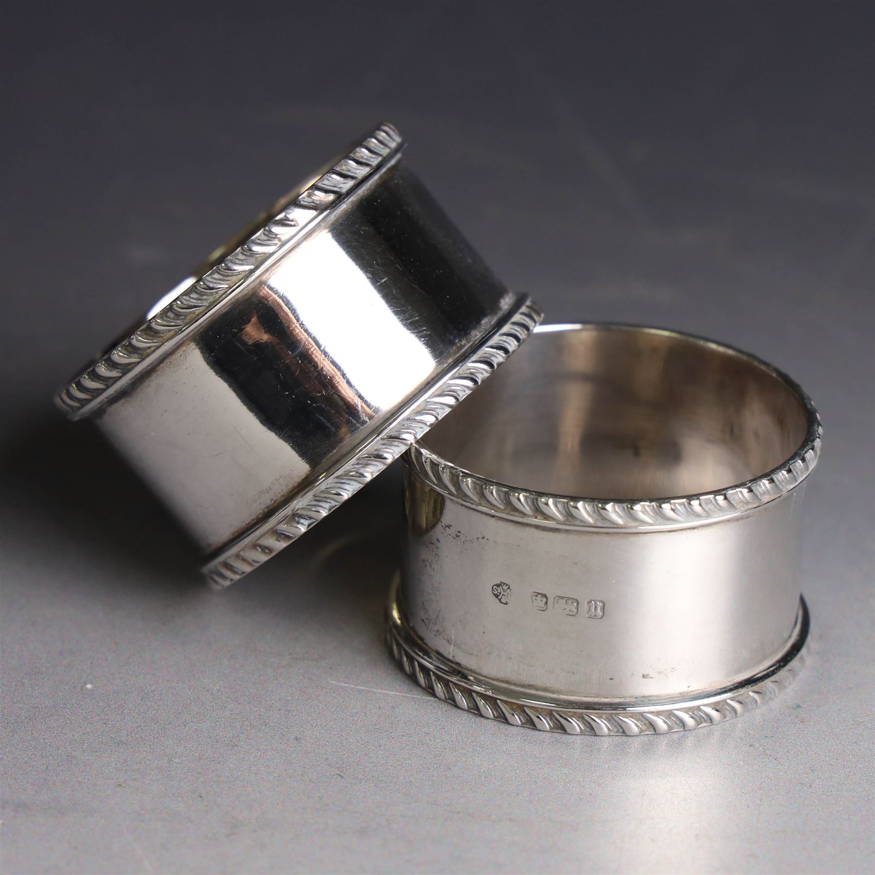 Pair of early 20th century silver napkin rings, plain circular form with oblique gadrooned rim, no engravings, hallmarked William Hutton & Sons Ltd, Sheffield 1912
