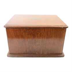 Oak table top canteen cabinet, the top with inset vacant brass cartouche, with pair of panelled doors opening to reveal four interior drawers with inset brass handle, containing a selection of silver plated flatware, 29cm x 40cm x 51cm