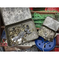 Meccano - large quantity of loose parts including various plates and strips, flanged plates, pulleys, axle rods and crank handles, wheels and tyres, gear wheels, brackets, nuts & bolts, various manuals; predominantly red and green; some in compartmentalised wooden trays