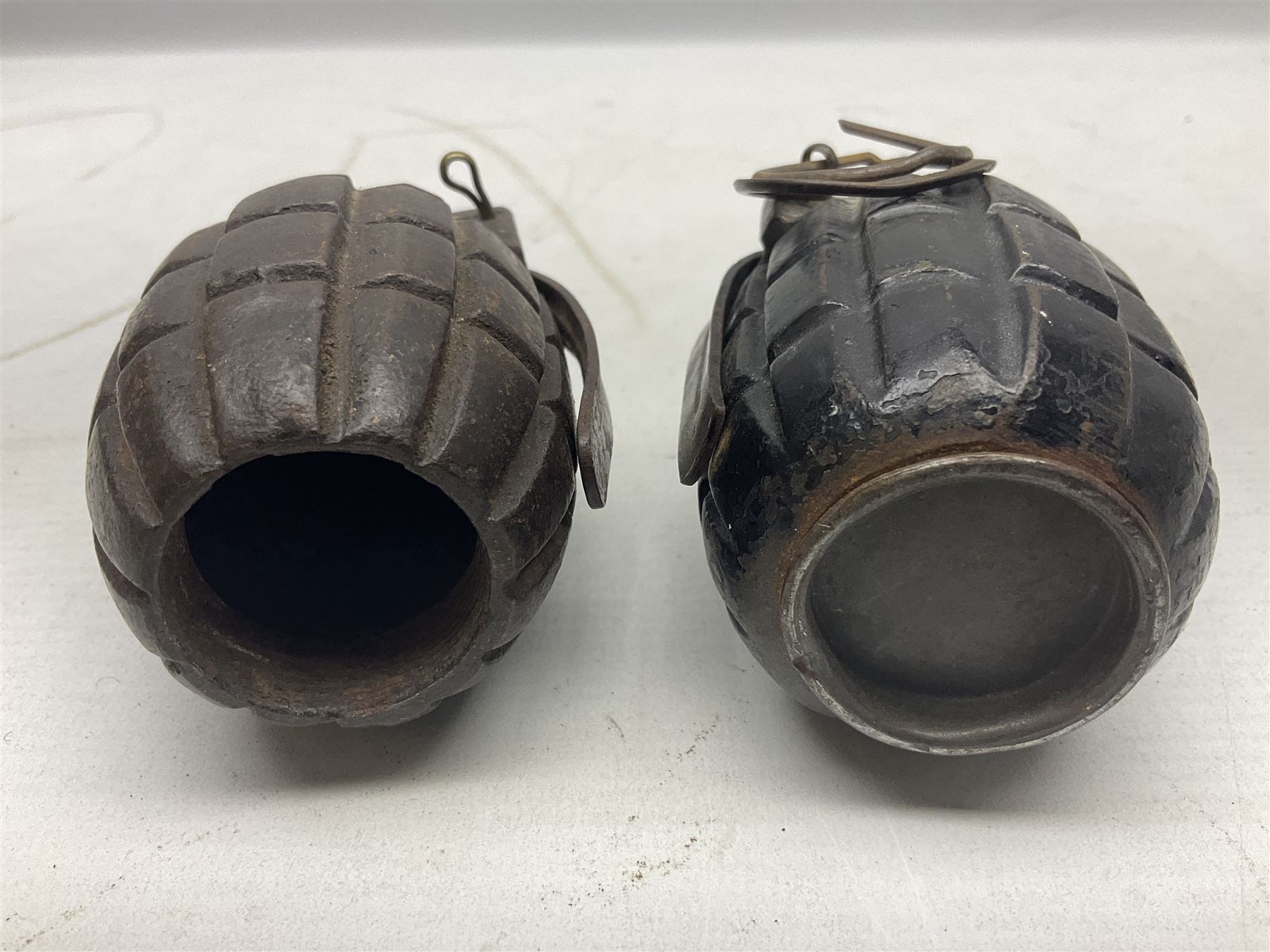 Two inert WW2 Mills Bomb (pineapple) hand grenades; one adapted as a money box with coin slit to the side and later cap H9.5cm (2)