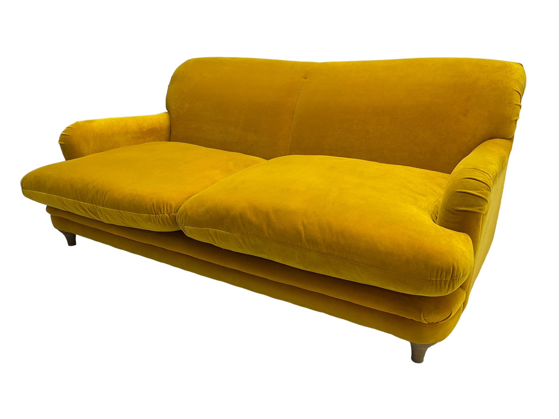 Loaf - large two seat 'Jonesy' sofa, upholstered in mustard velvet fabric with sprung back and loose seat cushions, raised on pale oak turned supports