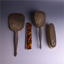 20th Century silver mounted dressing table set, comprising hand mirror, clothes brush, hairbrush and comb holder, each with engine turned and engraved floral decoration, three pieces hallmarked Adie Brothers Ltd Birmingham 1964, the comb holder hallmarked Elkington & Co Ltd Birmingham 1965, contained within a fitted tooled leather case