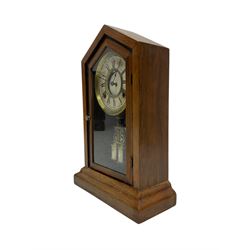 Late 19th century American shelf clock in a mahogany case with a fully glazed door on a stepped plinth, with a card dial with Roman numerals and minute track within a spun brass bezel, 8-day striking movement striking the hours on a bell, with faux mercury pendulum.
