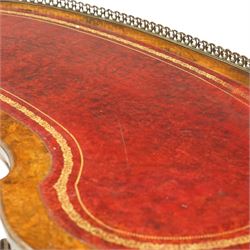 Victorian figured burr walnut kidney-shaped writing table, shaped top with pierced raised bras gallery back over inset red leather writing surface, fitted with two drawers flanking a pierced and carved scrolling apron, raised on turned and gadrooned twin pedestals with scroll-moulded cabriole supports with ceramic castors, united by ring-turned stretcher