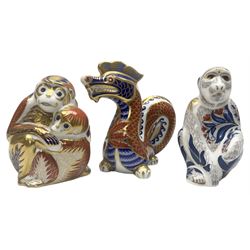 Three Royal Crown Derby paperweights, comprising Macaque, with gold stopper and original box, Monkey and Baby, with silver stopper and original box and Dragon with silver stopper, all with printed mark beneath  
