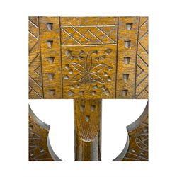 19th century swedish monk's chair, the oak frame with triangular seat and sloped arms, the backrest carved with geometric chipwork and a central pierced medallion 