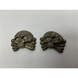 Five German 'SS' visor cap metal badges comprising one eagle and four skull and cross-bones (5)