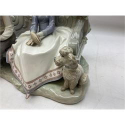 Lladro figure, Poetry of Love, modelled as a boy seated reading from a book next to a girl on garden bench with a dog at her feet, sculpted by Regino Torrijos, with original box, no 5442, year issued 1987, year retired 1998, H22cm