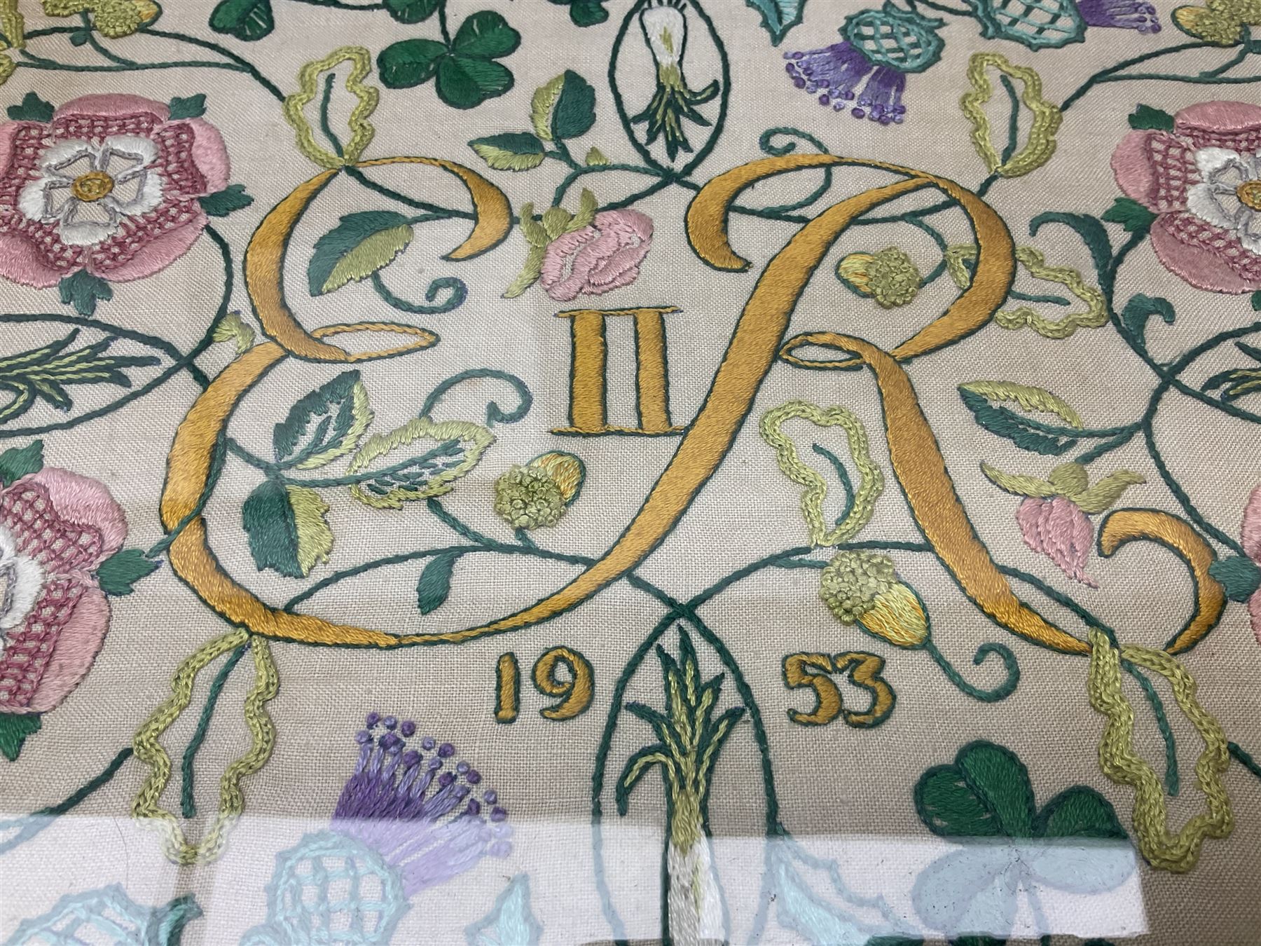 Two 1950s tapestries, the framed example celebrating the 1953 coronation, the second converted into a fire screen depicting a floral display, firescreen H70cm (2)