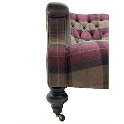 John Sankey - low armchair, buttoned back upholstered in tartan patterned fabric with contrasting grey leather, raised on turned and ebonised front feet with brass and ceramic castors, with matching foot stool