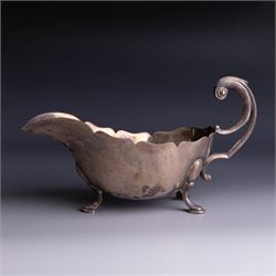 1930s silver sauceboat, of typical form with shaped rim and flying C scroll handle, upon t...
