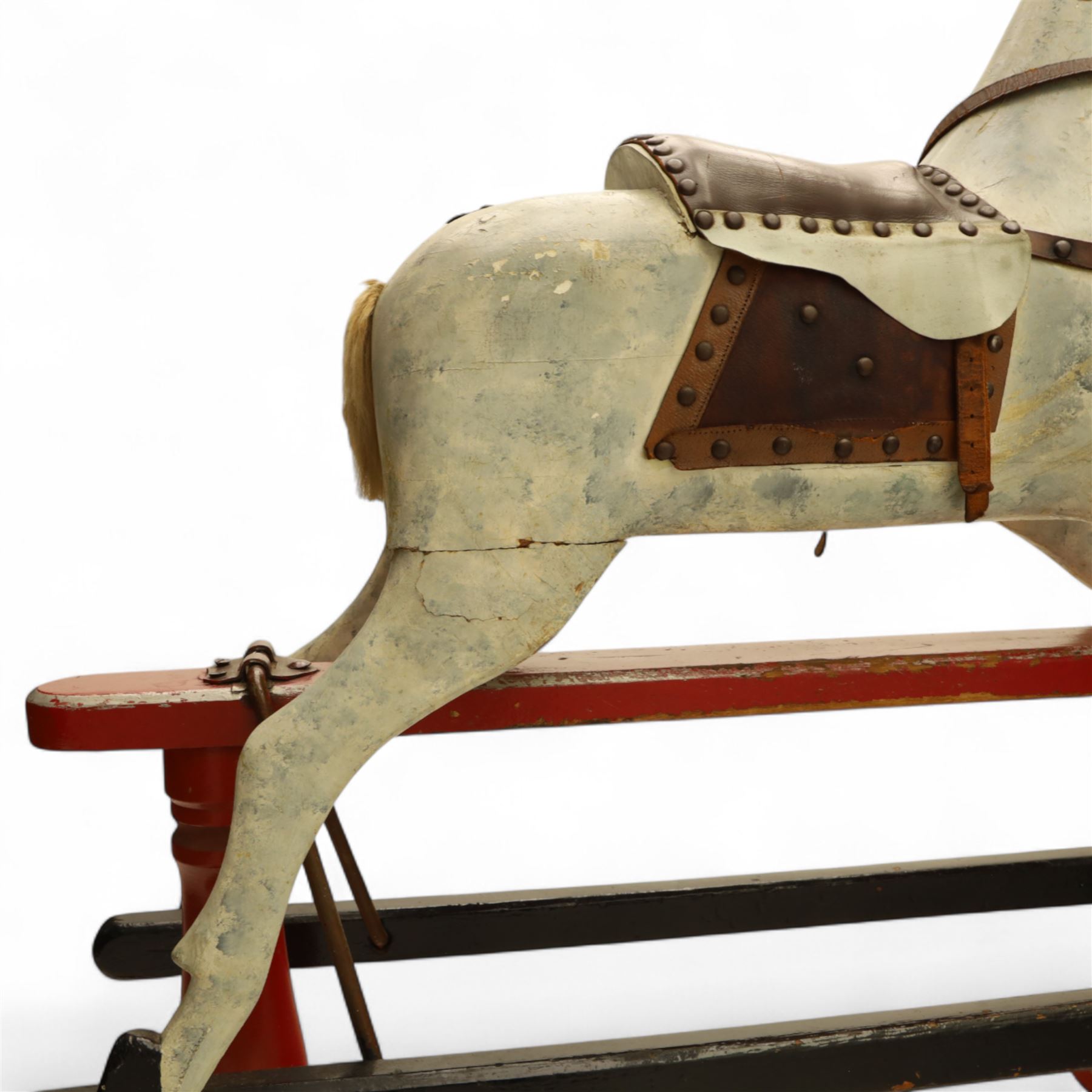 20th century carved and painted rocking horse, with original dappled paint finish, studded leather saddle and reins, on later red and black swing frame