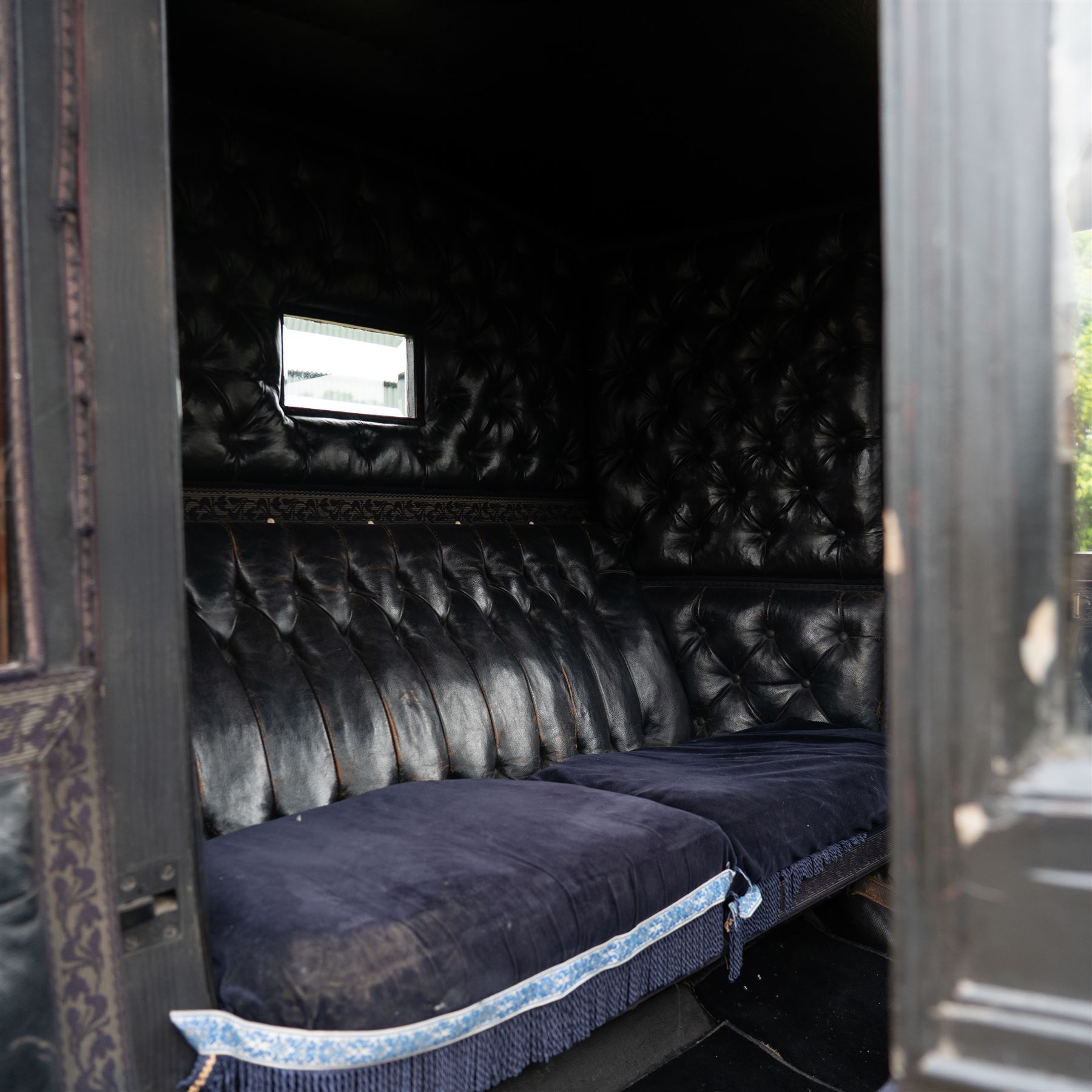 Town Coach by John Marstons Birmingham - Ex Film

A black painted five glass Town Coach by John Marston's Carriage Works Ltd, Birmingham, with enclosed glazed passenger compartment, curved front glass, external coachman's box seat and pole for driving with a pair of horses. The carriage has a timber coach body with buttoned black leather interior, blue upholstered seat cushions, plated exterior door handle, maker plates to the body and step, and John Marston marked hub caps. Mounted on black painted wooden spoked wheels with rubber tyres, leaf spring suspension, underbody turntable steering and iron fittings throughout.
Featured on the film set of 'Victoria' with Jenna Coleman

Features

• Black painted enclosed coach body
• Glazed passenger compartment with five windows
• Curved front glass
• Buttoned black leather interior
• Blue upholstered seat cushions
• External coachman's box seat
• Timber coach body
• Wooden spoked wheels
• Rubber tyres
• Leaf spring suspension
• Underbody turntable steering
• Pole for pair of horses
• Iron foot steps
• Plated exterior door handle
• Maker plates for John Marston's Carriage Works Ltd, Birmingham
• John Marston marked hub caps
• Featured on the film set of Victoria with Jenna Coleman

Dimensions:
Overall length: 390 cm
Width: 190 cm
Height: 214 cm

Wheel Diameters:
Front wheels: 104 cm
Rear wheels: 134 cm

Seating:
Coachman's box: 2
Passenger compartment: 4