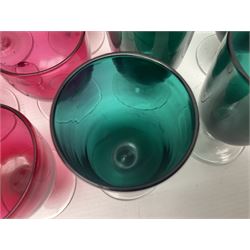 Collection of 19th century coloured glasses, to include nine cranberry glass punch cups, each with clear glass handle and foot and a set of six green glasses, with short clear stems, tallest H10cm