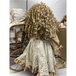 Two decorative wicker dolls prams, one with lace parasol,  and eleven dolls, including Leonardo Collection porcelain dolls, tallest pram including parasol H105cm
