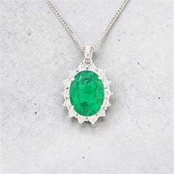 18ct white gold emerald and diamond pendant necklace, single oval cut  emerald of approx 3.25 carat, surrounded by fourteen round brilliant cut diamonds, on a fine link chain necklace, hallmarked, total diamond weight approx 0.50 carat