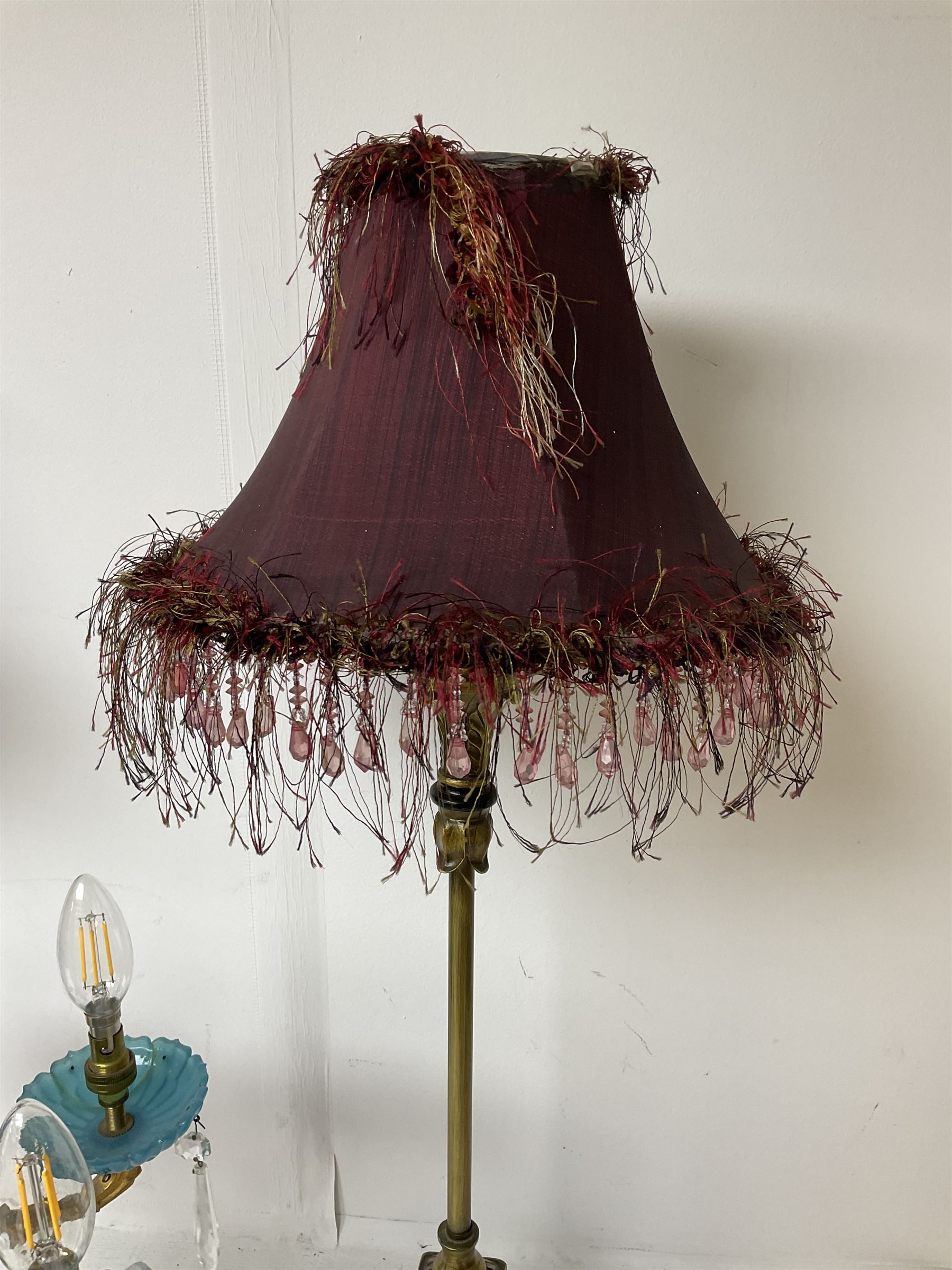 Brass table lamp, modelled as a candelabra with five branches, each with blue glass candle holders with crystal drops, H47cm, together with a pair of cast metal table lamps with acanthus leaf detail, upon a stepped square base, with red fabric feather and tassel shades, H78cm