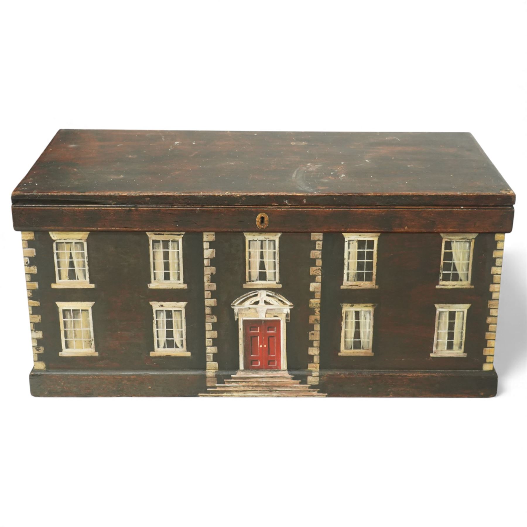 Georgian style painted wooden country house box, the rectangular hinged lid enclosing a plain interior, the exterior decorated as a symmetrical Georgian facade with sash windows, and central stepped and pedimented doorway, with moulded base and top edge