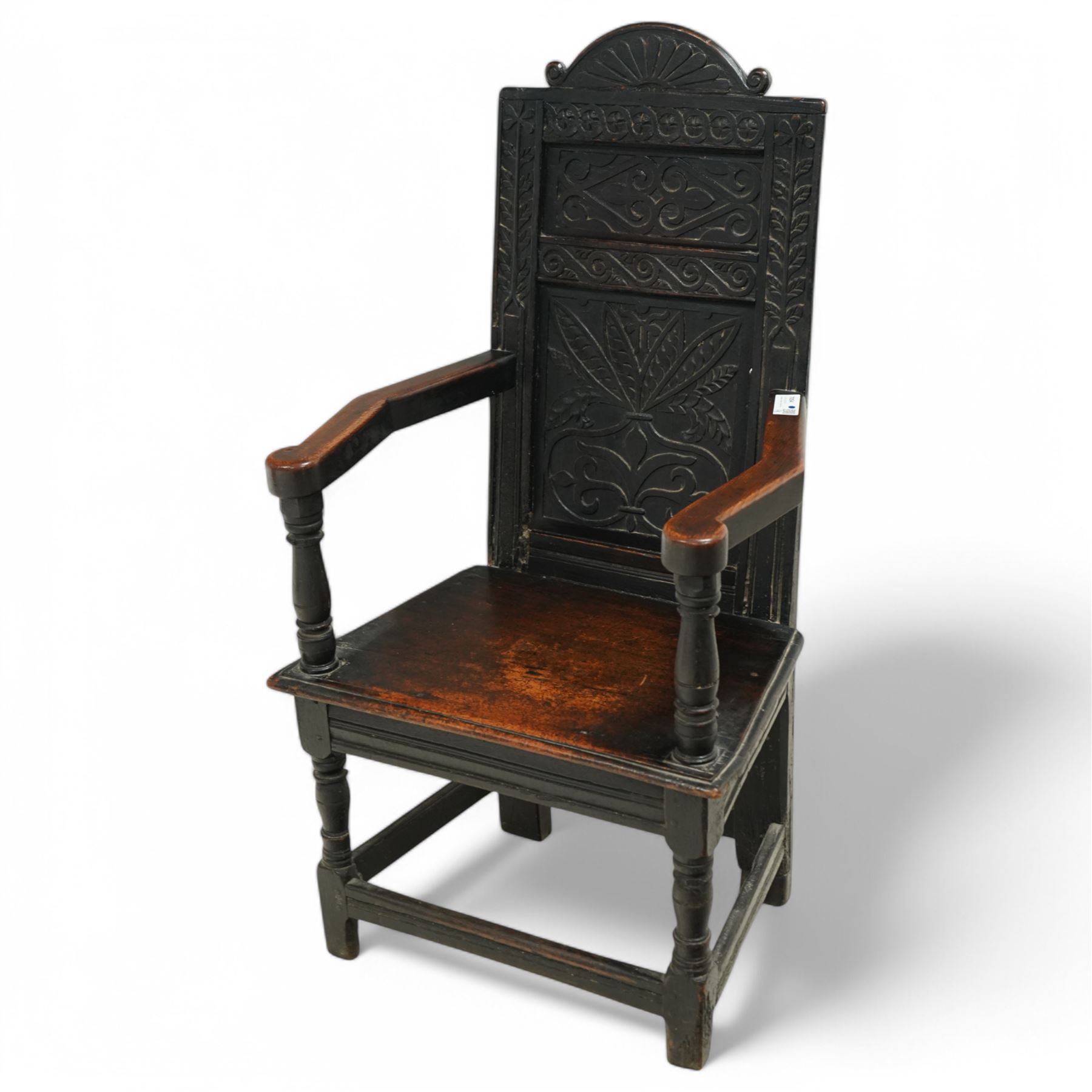 17th century and later carved oak Wainscot chair, the panelled back decorated with carved foliage and scrolls, the frame decorated with trailing guilloche and foliate motifs, moulded seat over turned supports united by stretchers 