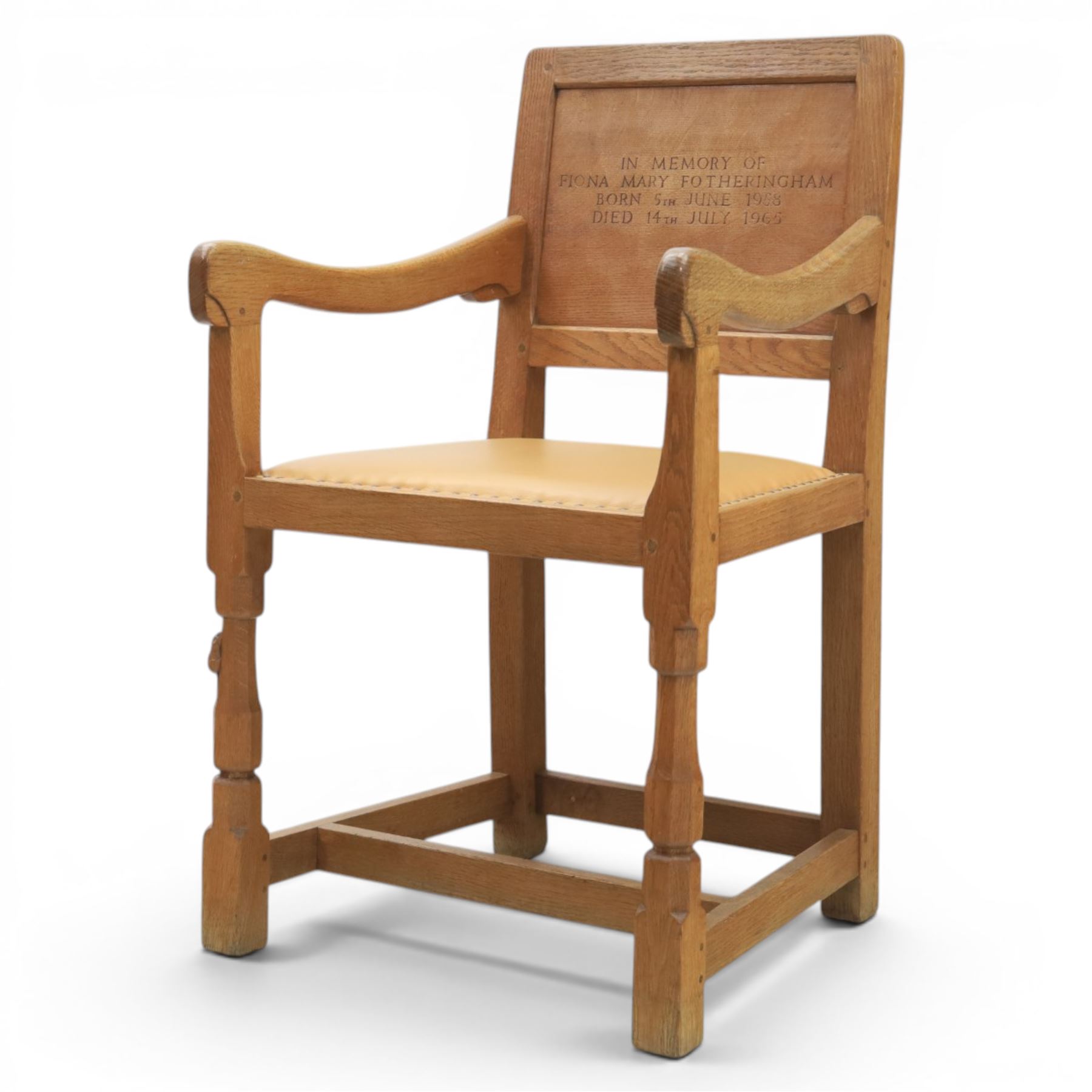 Mouseman - oak panel back carver armchair, with commemorative back panel engraved 'In memory of Fiona Mary Fotheringham Born 5th June 1958 Died 14th July 1965', above tan seat with brass studded trim, with carved Mouse signature, by Robert Thompson's of Kilburn