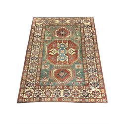 Kazakh rug, pale green ground field with three part medallion, three band border decorated with stylised plant motifs