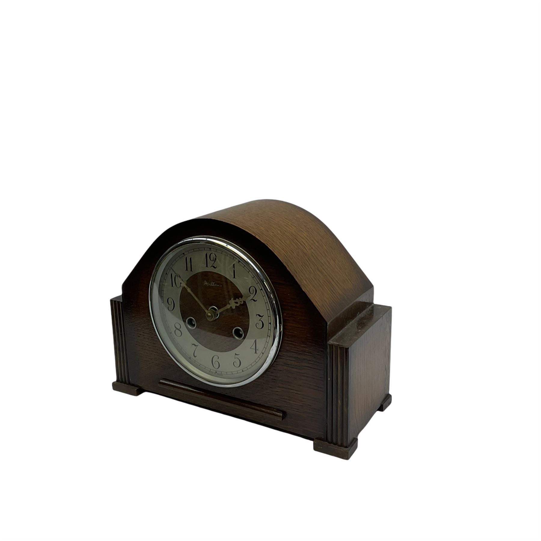 Oak cased mid-20th century “Bentima” English eight-day spring driven mantle clock with a striking movement striking the hours and half hours on a coiled gong, movement stamped for the Perivale Clock Manufacturing Company Ltd, London, with a silver finished chapter ring, upright Arabic numerals and minute track , baton hands and chrome bezel with glass.