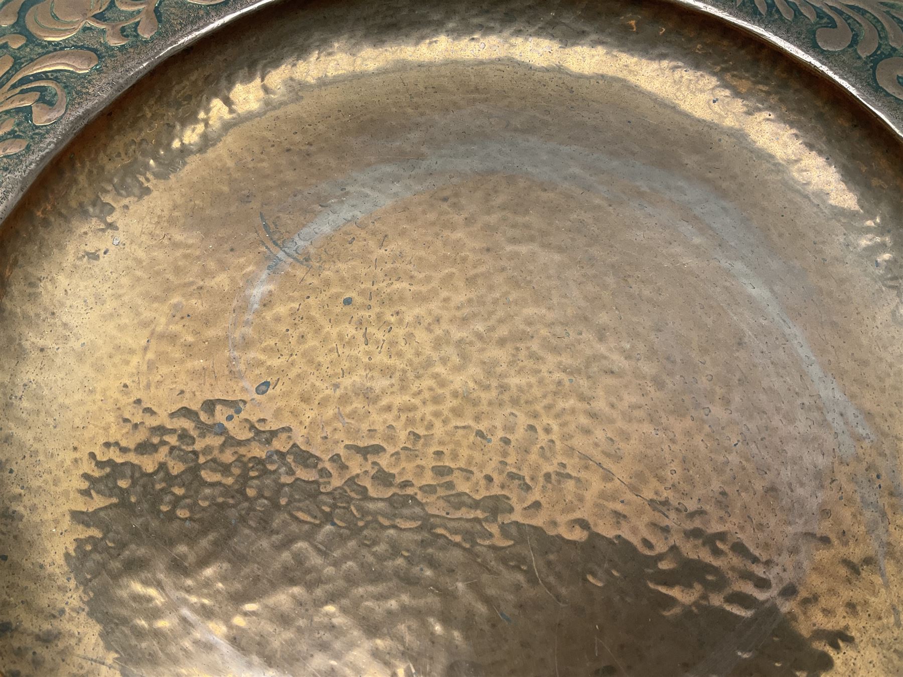 Arts and Crafts Keswick School of Industrial Arts copper charger, decorated with planished centre and repousse scrolling foliate tendrils to rim, D44cm