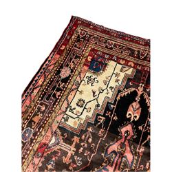 Persian Hamadan rug, with central pole medallion on dark field decorated with stylised motifs, ivory ground spandrels, multi-band border decorated with trailing stylised motifs 