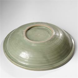 Chinese Ming dynasty Longquan celadon dish, the base carved with a lotus within a ribbed surround D35cm