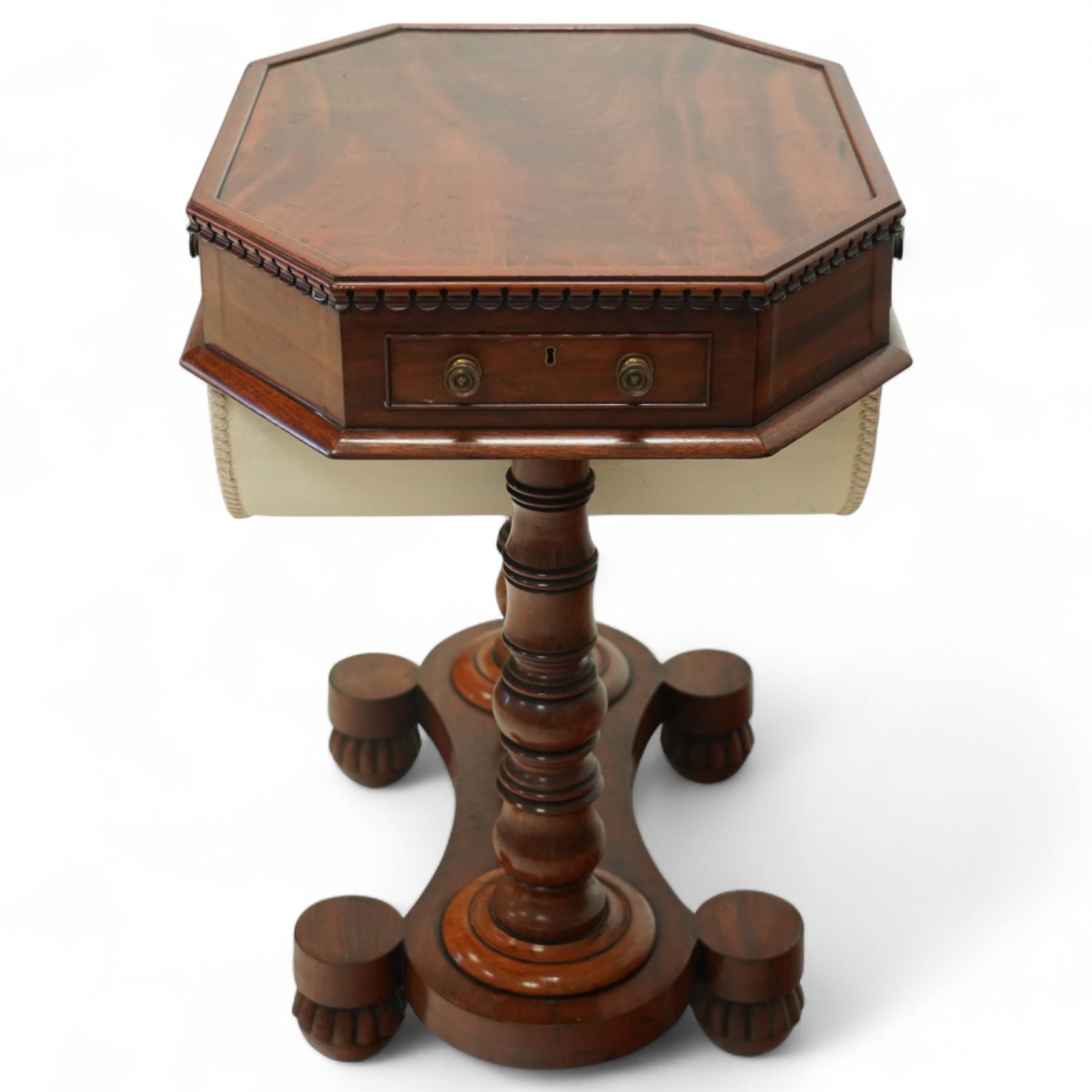 William IV mahogany work table, the octagonal top with ebony line inlay and dentil moulded edge, fitted with four small drawers to the frieze, above a silk-pleated sliding work basket, all raised on a turned column supports and shaped platform base with rounded feet, circa 1835