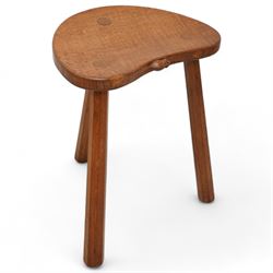 Mouseman - oak three-legged stool, dished kidney-shaped seat on three octagonal splayed supports, carved with mouse signature, by the workshop of Robert Thompson, Kilburn