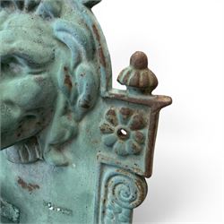 Antique cast iron wall fountain, cartouche cresting rail over a lion mask spout, with scroll and floral decoration over a scalloped basin, in rustic turquoise painted finish with rusted patina