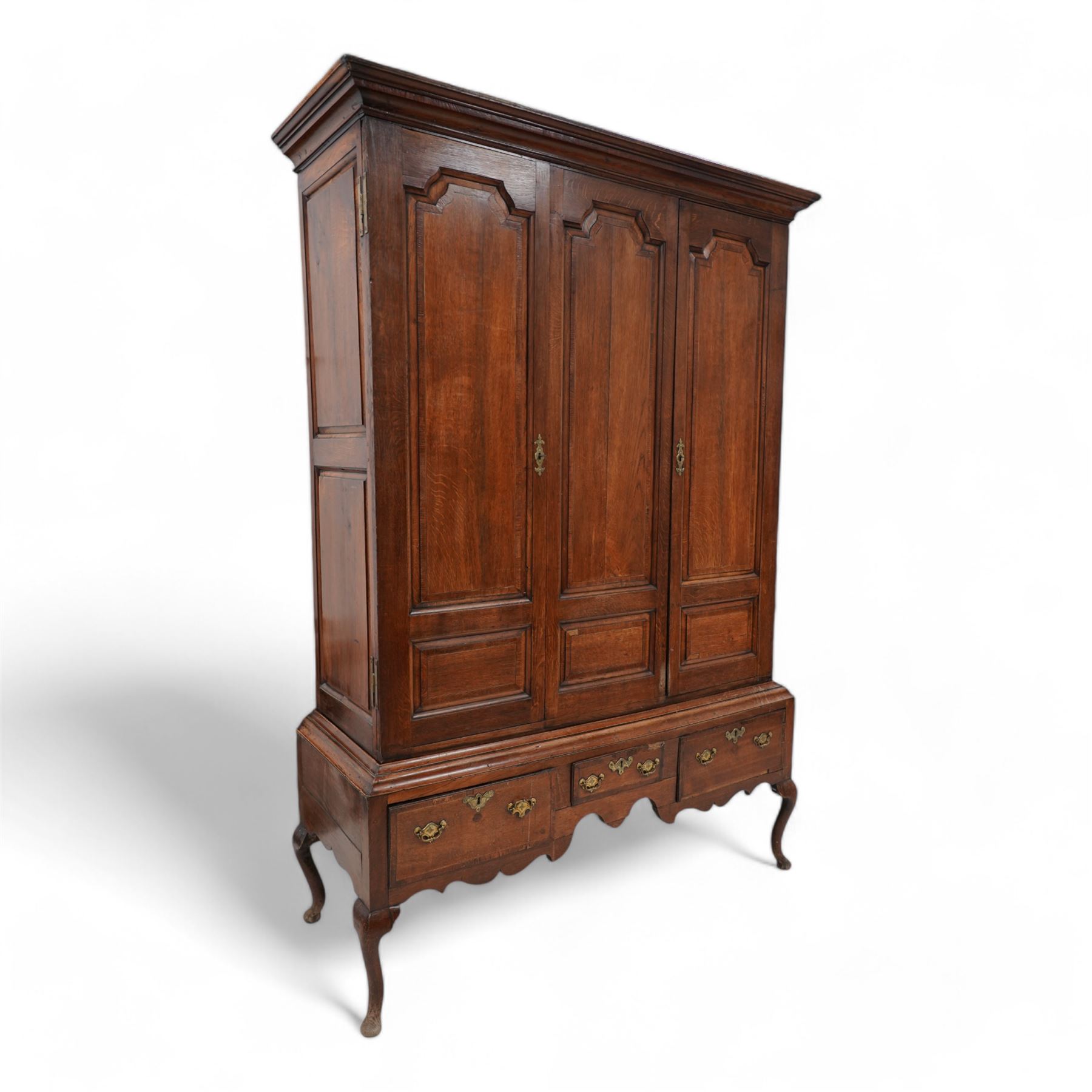 Georgian oak livery cupboard, projecting cornice over panelled front with mahogany bandings, enclosed by two doors, the base fitted with three drawers over shaped apron and cabriole supports 