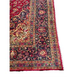 Persian Kashan carpet, red ground field decorated all-over with stylised floral motifs and interlacing branch, floral design central medallion and spandrels, the border decorated with plant motifs and scrolls