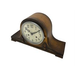 An oak cased 1930's Tambour mantle clock with carved decoration raised on four feet, with a silver effect 6'' dial, applied Arabic numerals, minute track and steel serpentine hands, within a convex glass and chrome bezel, eight-day striking movement, striking the hours and half-hours on a coiled gong. With pendulum.



