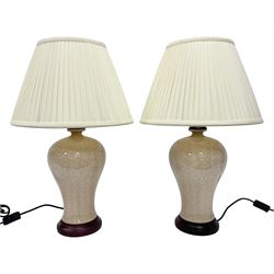 Pair of table lamps of baluster form, decorated in a mosaic pattern in a pale apricot glaze, upon a circular base, including shade H60cm