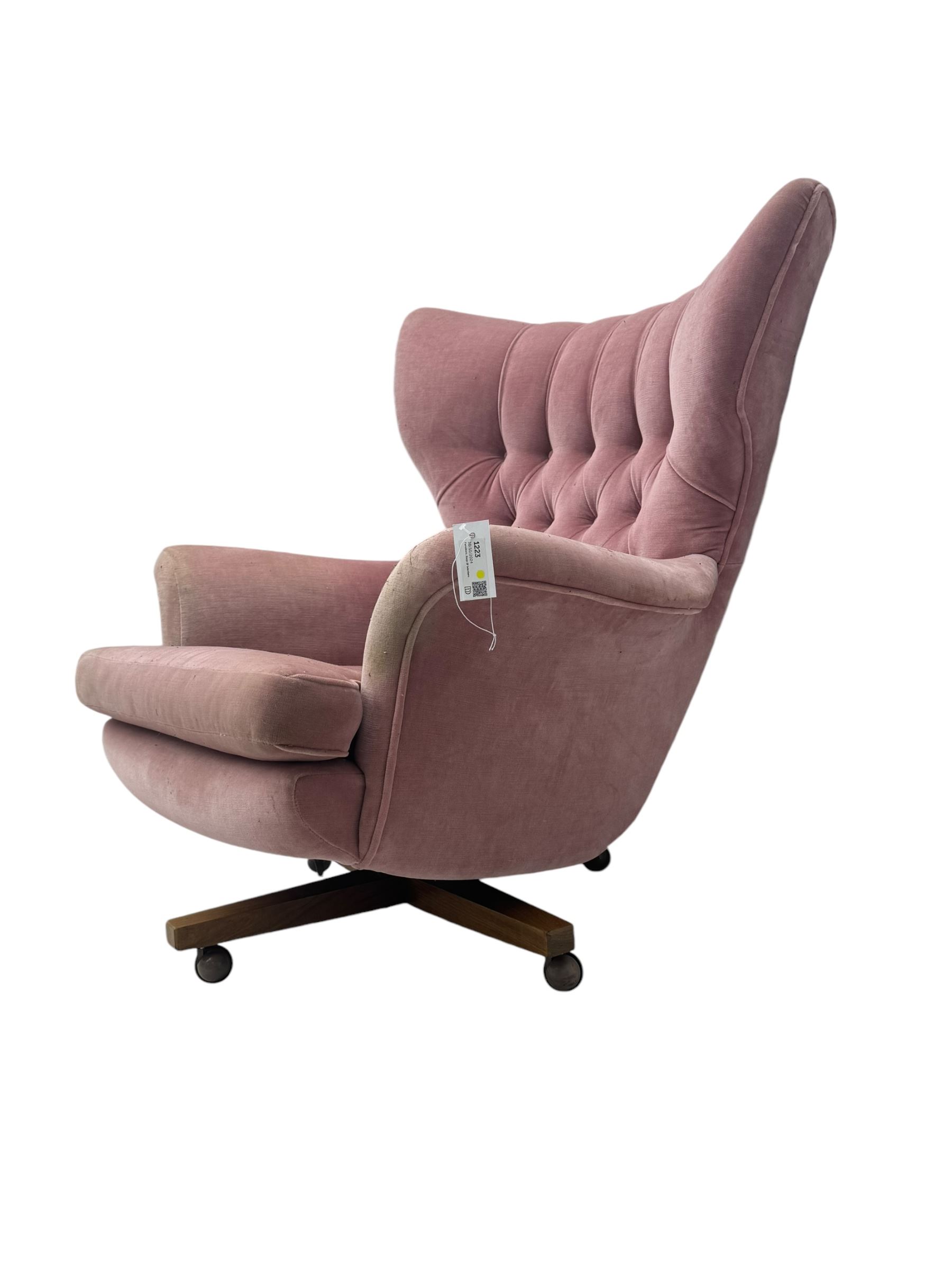 Paul Conti for G-Plan - 'Blofeld' Model 6250 swivel wingback armchair, upholstered in pink velour button back fabric, on teak base with castors