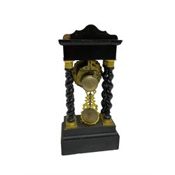 French - 19th century 8-day ebonised portico clock, shaped pediment with inlay and four barley twist columns with brass capitals, double plinth with conforming inlay, enamel dial with a filigree stamped bezel, Roman numerals, minute markers and maltese cross hands, distinctive repousse pendulum, twin train Parisian count wheel striking movement, striking the hours and half-hours on a bell. 