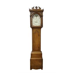 George Clapham of Brigg - Late 18th century 8-day oak cased longcase clock c1790 - flat topped hood with later carved addition, dog tooth moulding and blind fretwork beneath, break arch hood door flanked by reeded pilasters and capitals, trunk with canted corners and  door with a triple arched top, plinth with a later base with decoratively shaped feet, early painted dial with flowers enclosed in a gesso border to the spandrels, rolling moon to the arch, seconds dial and calendar aperture, Roman numerals and five minute Arabic's with makers name (indistinct), dial pinned via a false plate to a rack striking movement. With weights, key and pendulum.