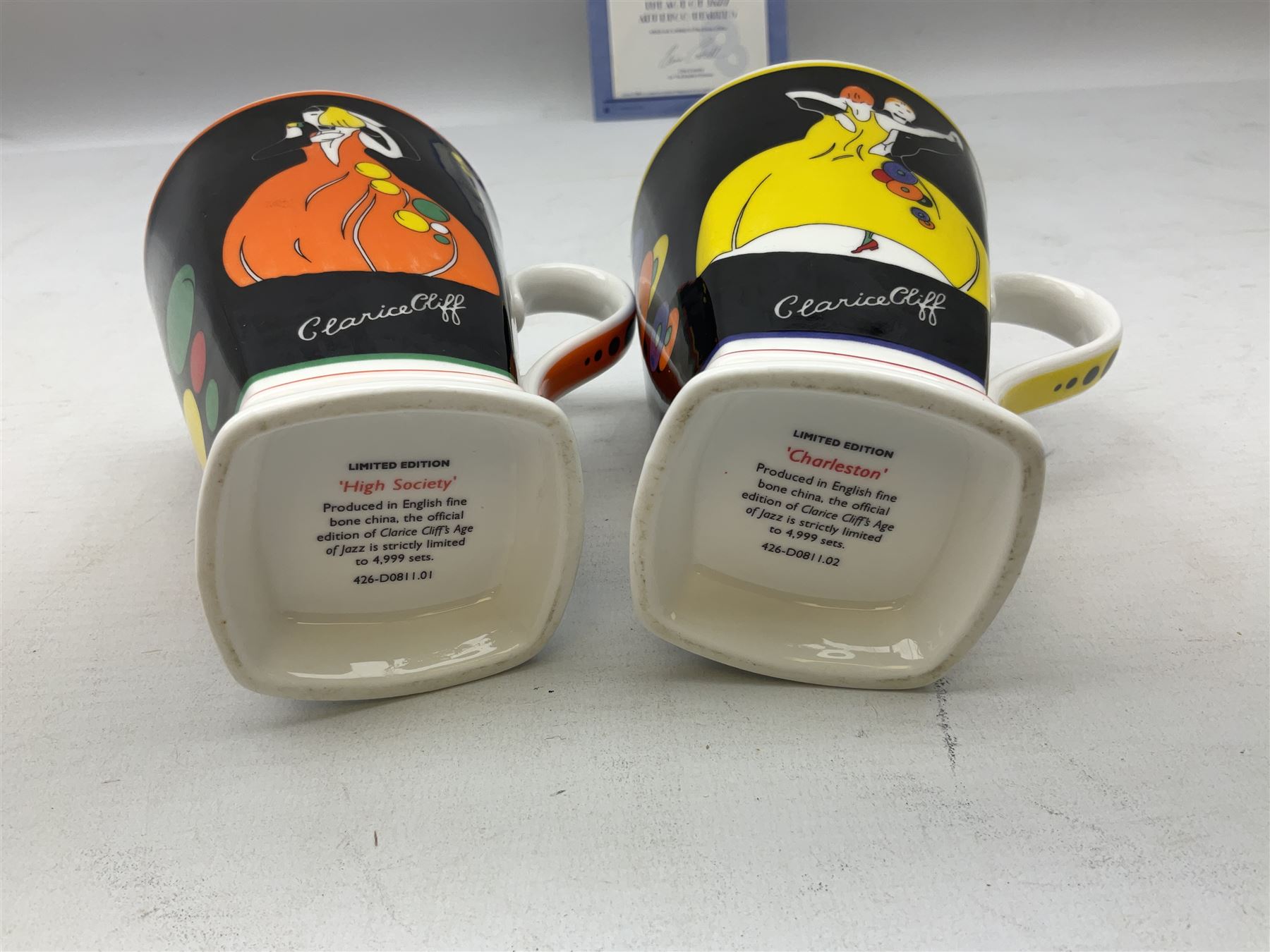 Two limited edition Bradford Exhange Clarice Cliff Age of Jazz beakers, no 289/4,999, with certificate, in box, together with a Moorland Art Deco Clarice Cliff style Huntley Cottage pattern teacup and saucer 