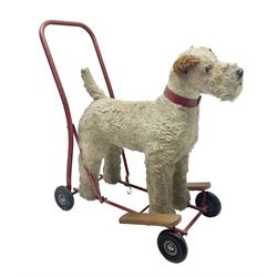 Tri ang - Pedigree Soft Toys - push along/ride-on dog as a wood wool filled plush Airedale terrier in red tubular frame with beech footrests and black rubber wheels; stitched Northern Ireland label in tact L60cm H61cm